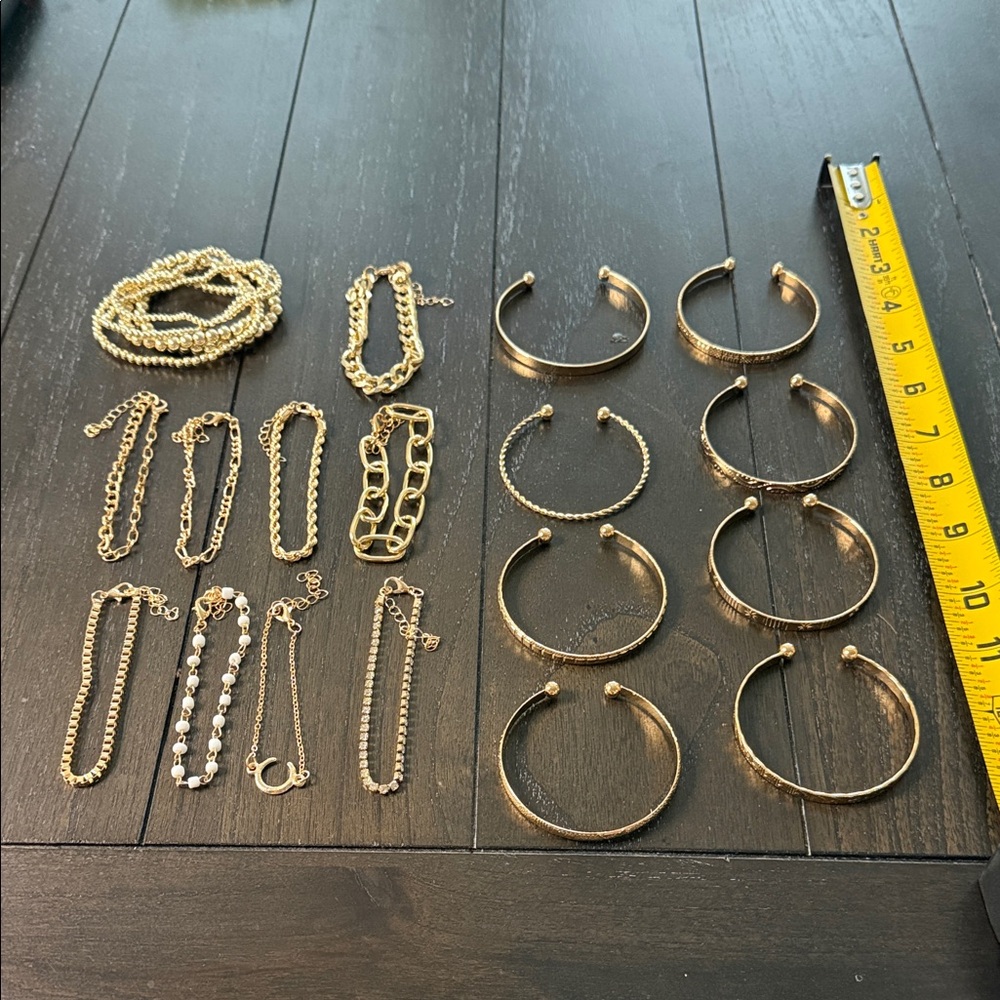 Random assortment of 22 gold and white bracelets